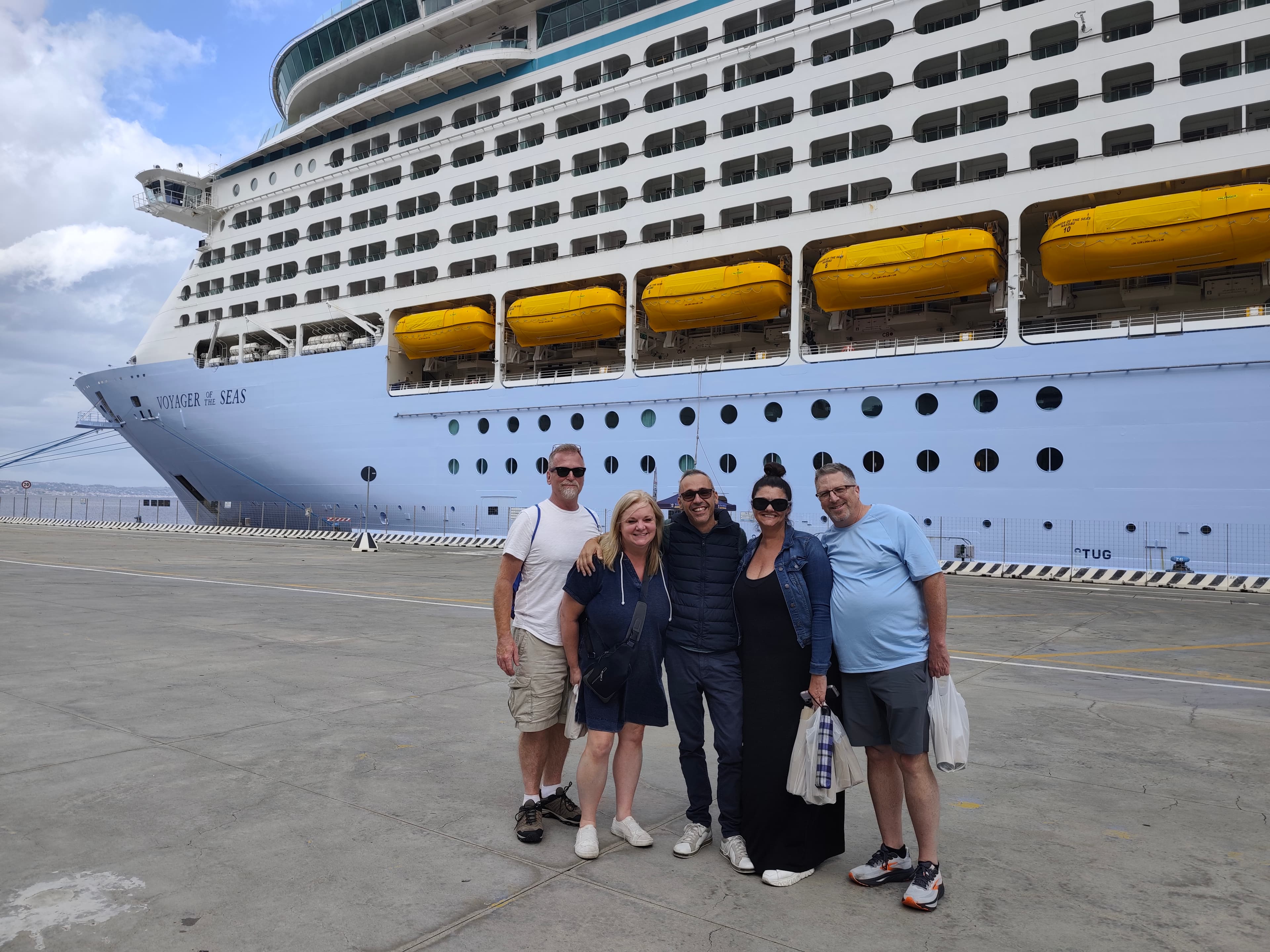 Cruise passengers with local Sicily tour guide in front of Royal Caribbean Voyager of the Seas at Messina cruise port, Sicily.